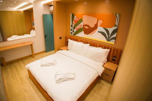 a bedroom with a bed with two towels on it at Solen Suites in Korçë