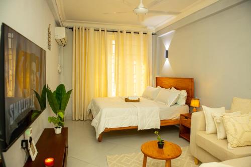 a hotel room with a bed and a couch at Nyumbani 2 studio in Dar es Salaam
