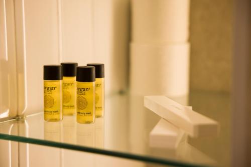 three bottles of mustard sitting on a glass shelf at Solen Suites in Korçë