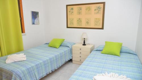 a bedroom with two beds and a dresser and a picture at La Playa 2 B in La Laja