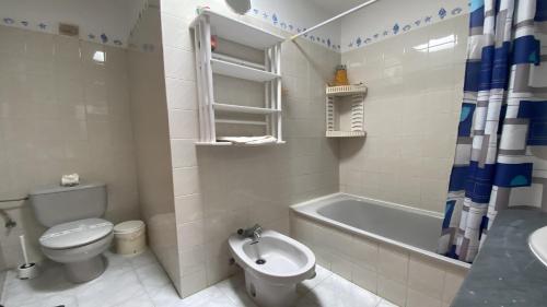 a bathroom with a toilet and a tub and a sink at La Playa 2 B in La Laja