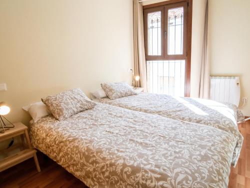 a bedroom with a bed with a white comforter and a window at El Rinconcico in Valdelinares