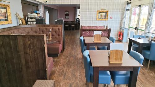 a restaurant with tables and chairs and a counter at Chieftain Hotel in Inverness