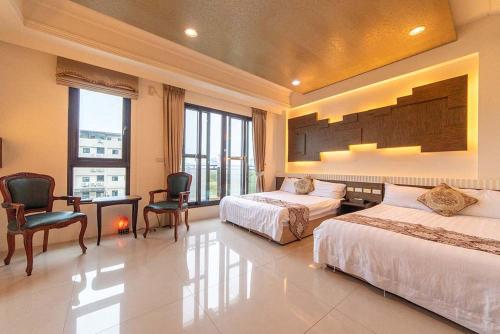 a bedroom with two beds and a desk and chairs at Lambo Stay Inn in Toucheng