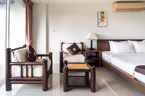 a hotel room with a bed and a chair at Patong hillside Condo with pool, bar, parking in Patong Beach