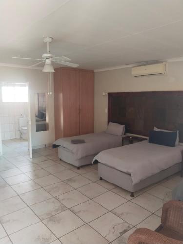 a bedroom with two beds and a ceiling fan at Claypot Guesthouse in Northam