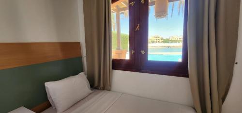 a bed in a room with a window with a view at Nayah Stays, Lagoons beach, Paradise 3 ensuite with private pool in El Gouna