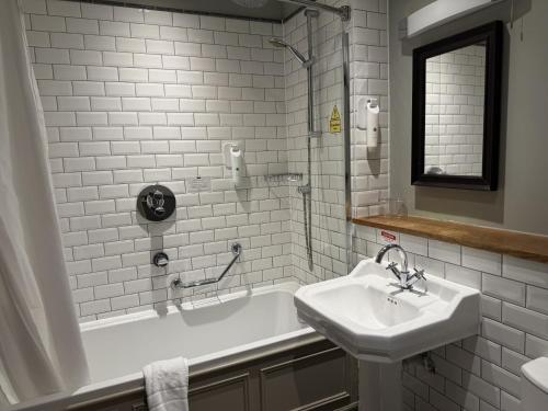 a white bathroom with a sink and a tub and a sink at Red Lion Hotel by Greene King Inns in Fareham