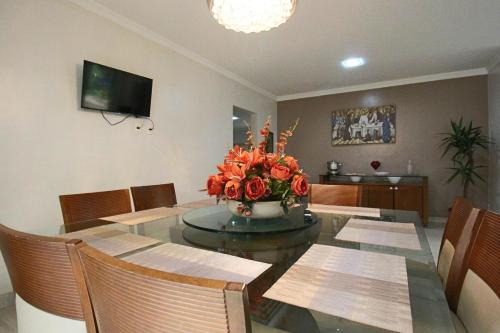 a dining room with a table with a vase of flowers at Casa com Piscina e Churrasqueira em Taguatinga in Taguatinga