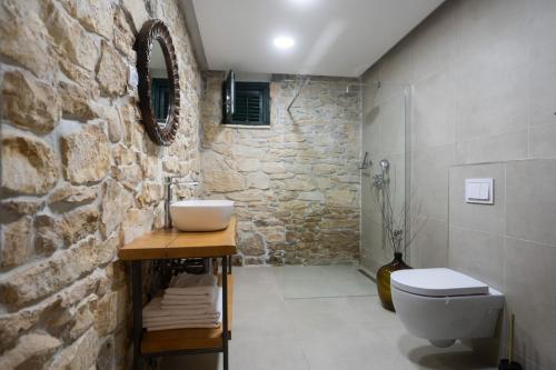 a stone bathroom with a sink and a toilet at Villa Dvori Jokic in Islam Grčki