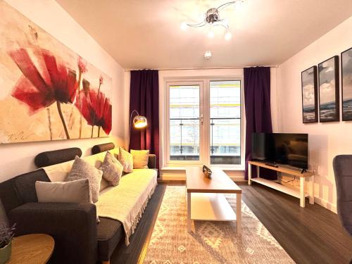a living room with a couch and a television at VIPAbodes at The Nankeville Woking in Woking