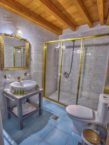a bathroom with a shower and a toilet and a sink at Papigo Towers in Papigko