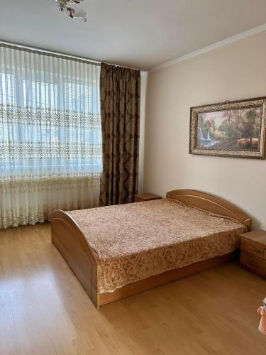 a bedroom with a bed and a large window at Садиба Villa Bella in Velyatyn