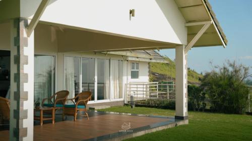 a patio with two chairs and a table on a porch at The Upper Deck in Pīrmed