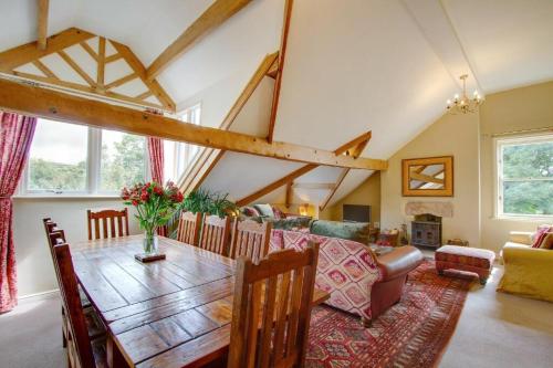 a living room with a wooden dining room table at Moorgarth Hall Apartment, Ingleton, Yorkshire Dales in Ingleton