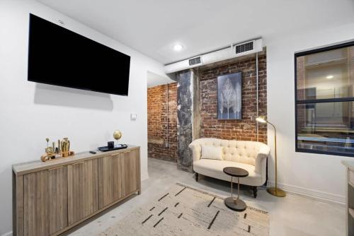 a living room with a couch and a tv on a wall at Park Hotel 1BR Suite 210 in Chattanooga