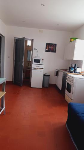 a kitchen with white appliances and a red tile floor at Bel Appartement Fonctionnel,2 grandes chambres separer plus un bz,WI FI,Clim in Digoin