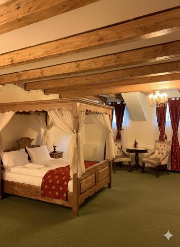 a bedroom with a canopy bed in a room at Boutique Hotel ,,Villa Franca'' in Sighişoara