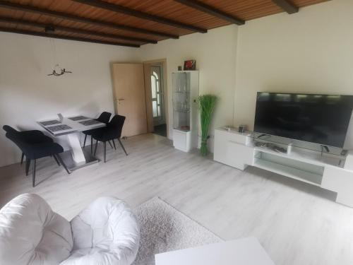a living room with a television and a table and chairs at Ferienwohnung Im Auricher Tal in Vaihingen an der Enz