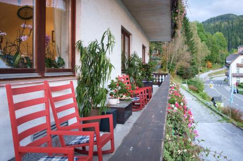 a row of red chairs sitting outside of a building at Alpenpension Gasthof in Ratten