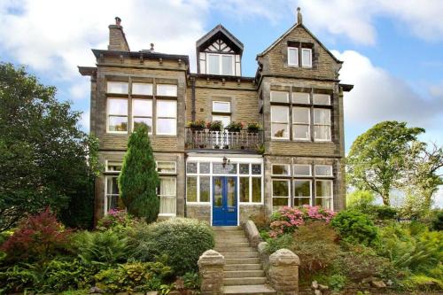 an old house with a blue door and stairs at Moorgarth Hall Apartment, Ingleton, Yorkshire Dales in Ingleton