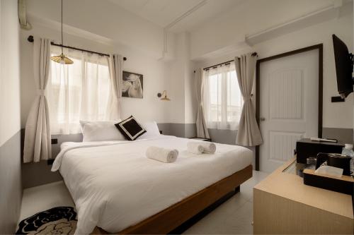 a bedroom with a large bed with towels on it at Chinoir Boutique Phuket Town in Phuket