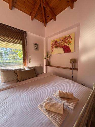 a bedroom with a large bed with two towels on it at Studio with garden in Selínia