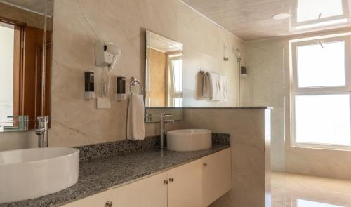 a bathroom with two sinks and a large mirror at Hotel Checkin El Cortecito Beach in Punta Cana