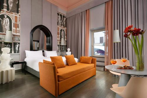 a hotel room with a bed and a couch and a table at Leon's Place Hotel In Rome in Rome