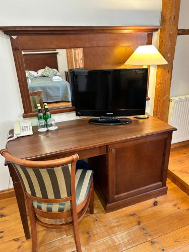 ein Holzschreibtisch mit einem Fernseher darauf in der Unterkunft Pałac w Rymaniu in Rymań