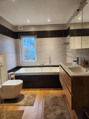 a bathroom with a tub and a toilet and a sink at B&B 't Greefsch Geluck in Kalmthout