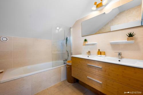 a bathroom with a sink and a tub and a shower at Koté La Savan' in Saint-Paul