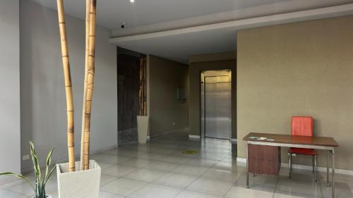 ein Esszimmer mit einem Tisch und einem roten Stuhl in der Unterkunft RP3 Studio in General Sarmiento