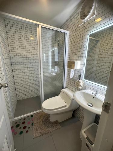 a bathroom with a toilet and a shower and a sink at 20 Tree Ville in Ban Ko