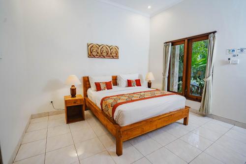 a bedroom with a large bed and a window at Kayuma House Canggu in Canggu