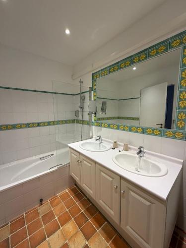 a bathroom with two sinks and a tub and a mirror at Hotel Les Suites - Domaine de Crécy in Crécy-la-Chapelle