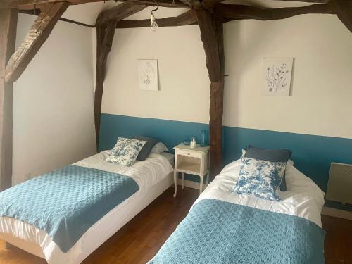 two beds in a room with blue and white walls at Le Petit Manoir avec Piscine Privée in Le Bugue