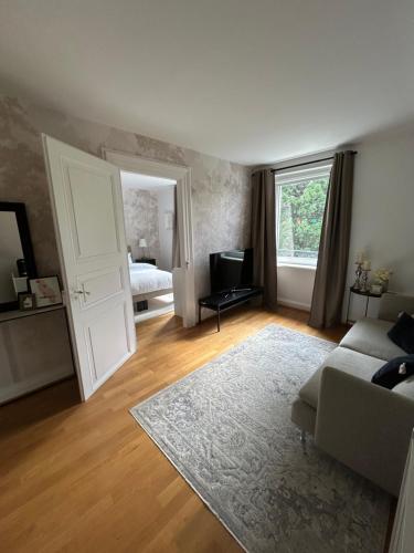a living room with a couch and a television at Suite JULIETTE Chambre d'hôte de charme in Mulhouse