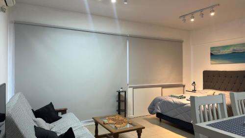ein Schlafzimmer mit einem Bett, einer Couch und einem Stuhl in der Unterkunft RP3 Studio in General Sarmiento