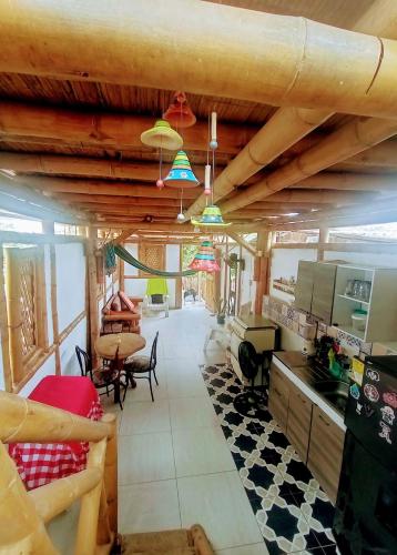a kitchen with wooden ceilings and a living room at Casa de Guadua in Dibulla