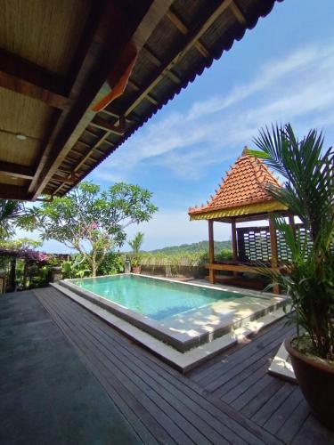 a swimming pool with a gazebo on a deck at Mayong Awan Cita in Munduk