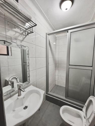a bathroom with a toilet and a sink and a shower at Sienna Beach Hotel - Entebbe in Entebbe