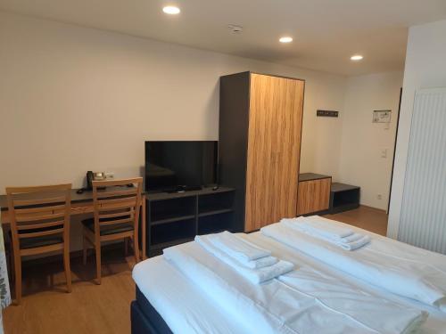 a bedroom with a bed and a desk and a television at Gasthof zur Post in Lalling