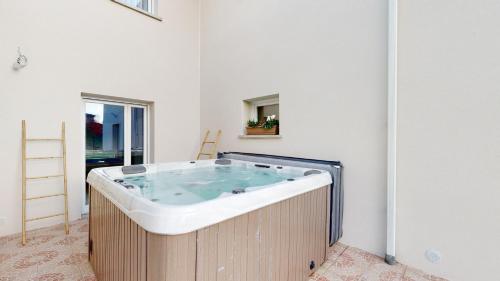 a large bath tub in a room with at Villa "La Recrée Toulousaine " Clim & SPA-12 couchages in Cugnaux