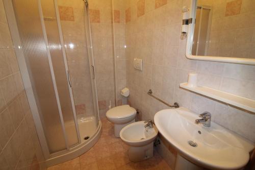a bathroom with a shower and a toilet and a sink at Residence Rondinelle in Lignano Sabbiadoro