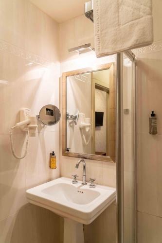 a bathroom with a sink and a mirror and a shower at Hotel Ptuj in Ptuj
