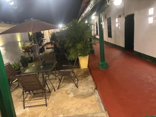 a patio with a table and chairs and an umbrella at HOTEL CASA VANIA MOMPOX, Centro histórico, Con Parqueadero en el Hotel in Mompos