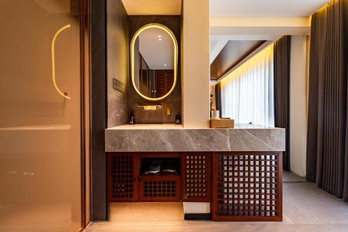 a bathroom with a sink and a mirror at MiLO Hearth米罗设计民宿 张家界天门山索道店 in Zhangjiajie