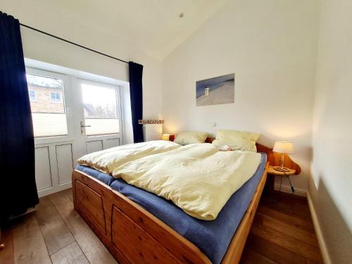 a bedroom with a large bed in a room with a window at Ferienhaus Hummel in Böhl