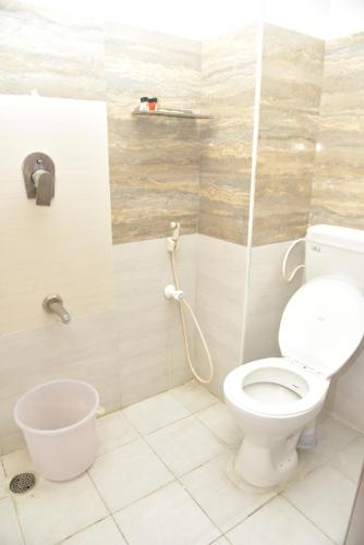 a bathroom with a toilet and a bucket at RD Hotel-Near Anna Statue in Perundurai